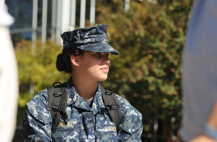 Woman in U.S. Navy fatigue with a bookbag on
